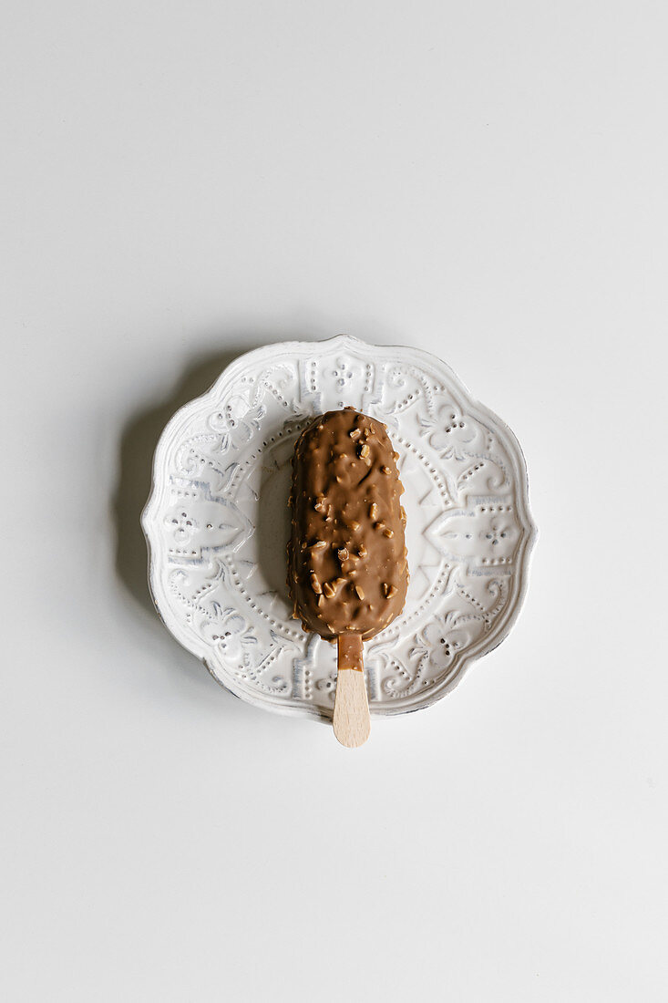 Almond chocolate ice cream on a stick, minimal concept