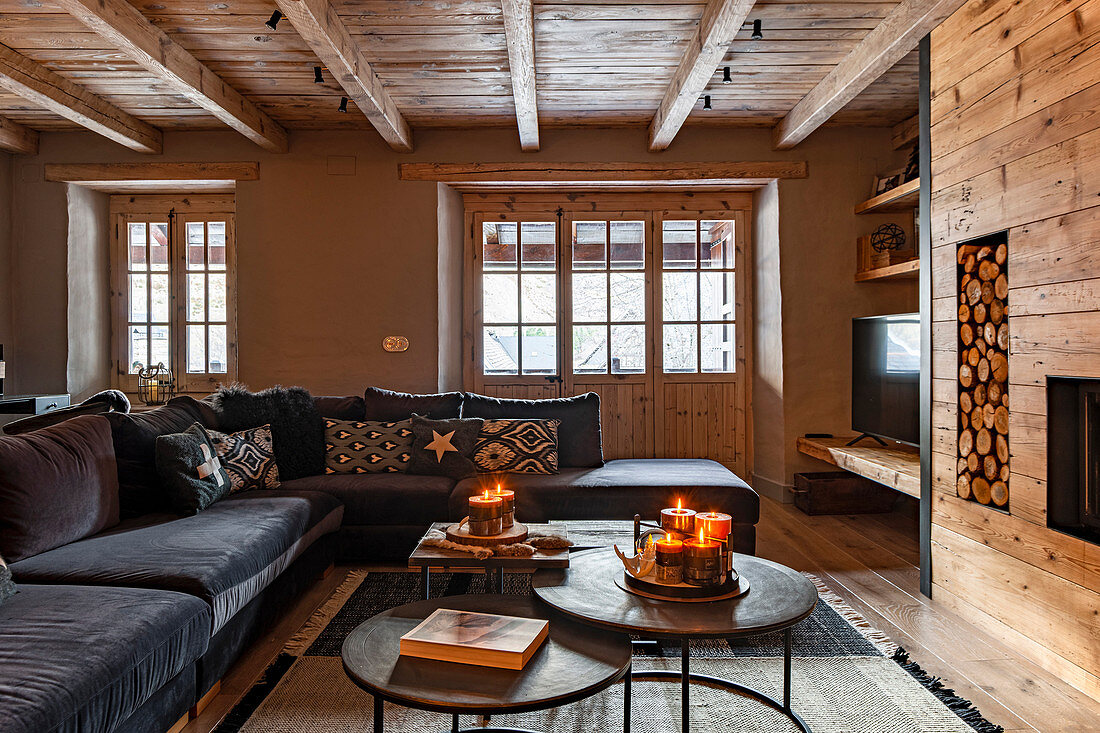 Sofa set in front of fire in cosy living room with wood panelling