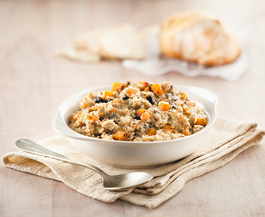 A bowl of quinoa risotto with mushrooms, carrots and vegetables.