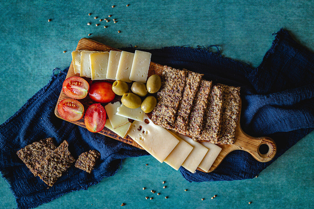 Cheese platter with olives, tomatoes and crispbread