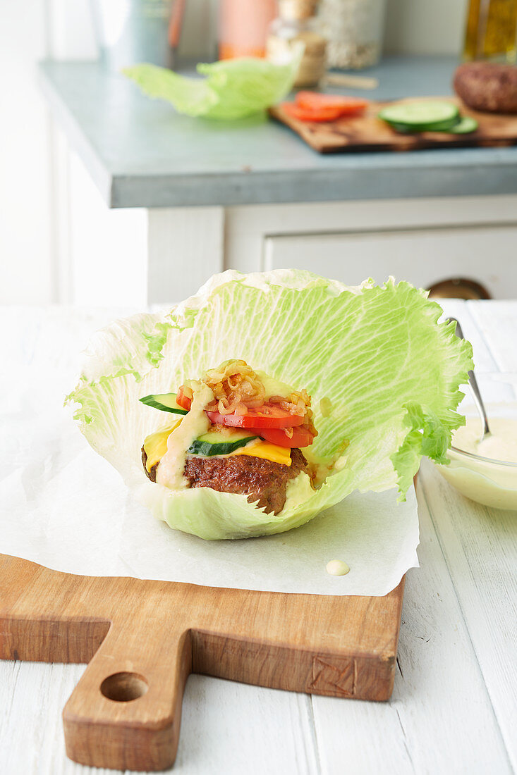 Lamb burger with tomato and cucumber on a lettuce leaf