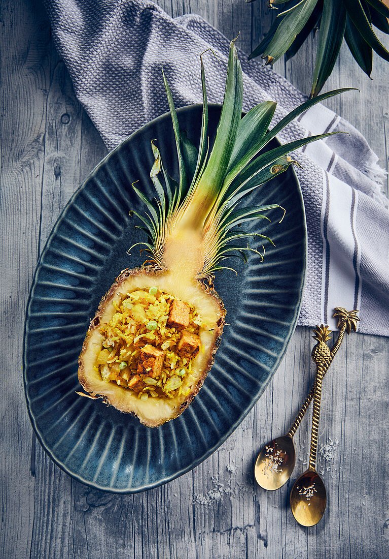 Stuffed pineapple with coconut and turmeric rice and curry tempeh