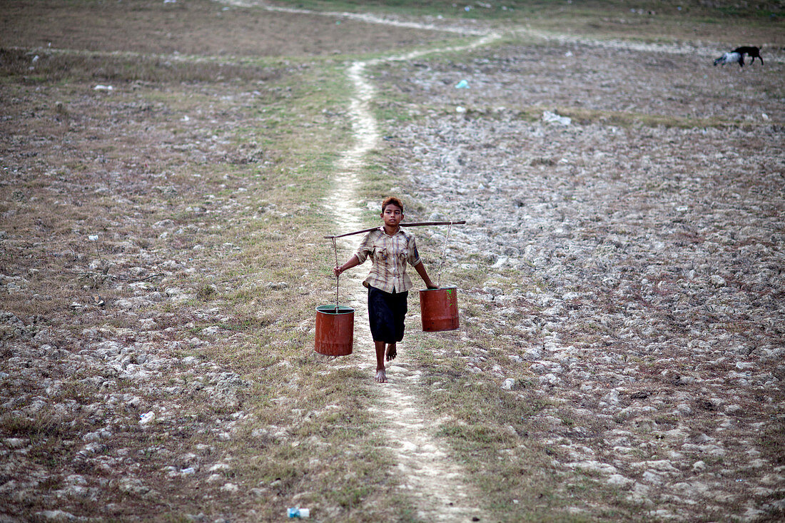 Boy carrying water, Myanmar