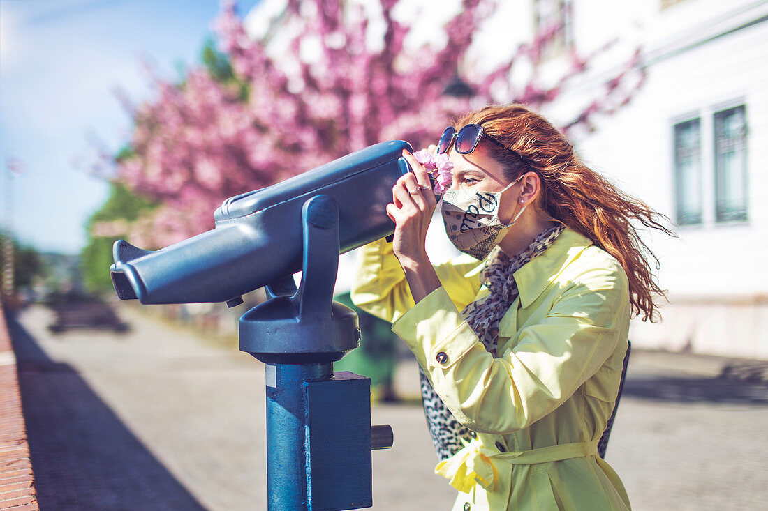 Woman using coin-operated binoculars