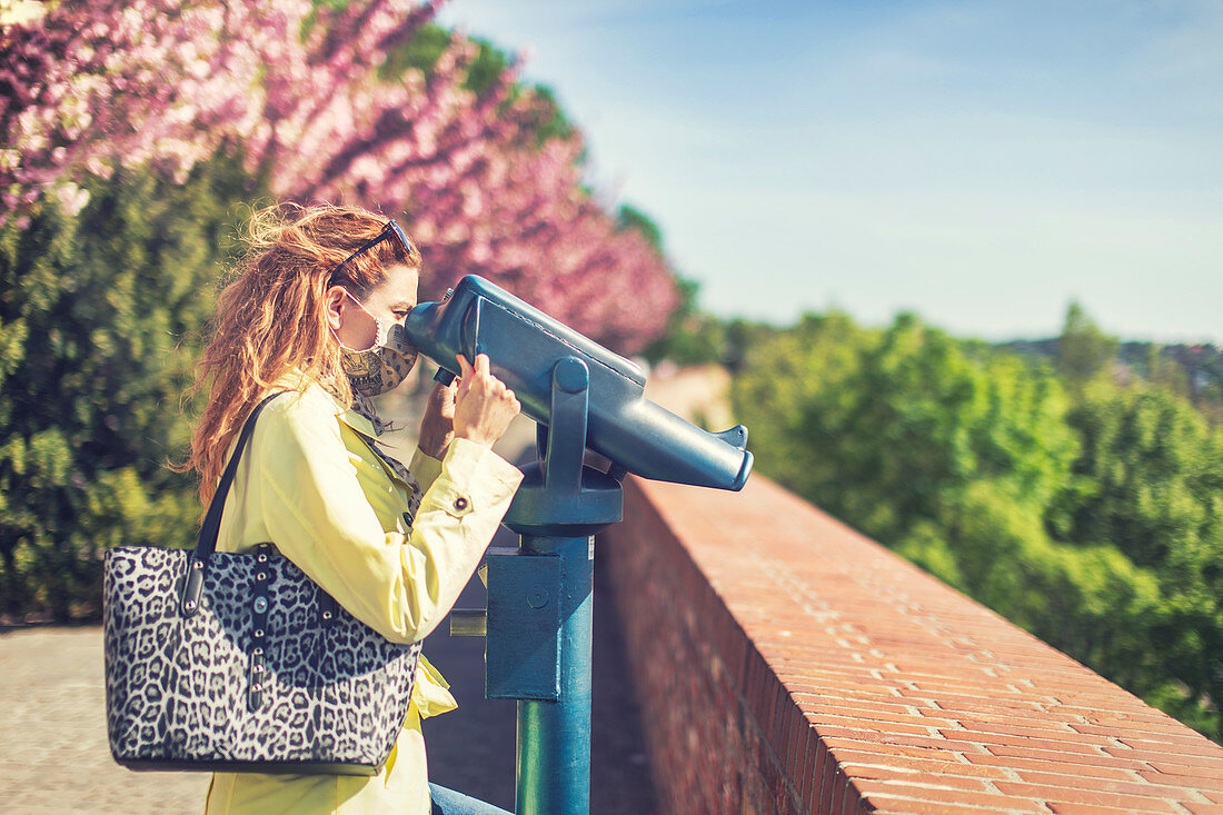 Woman using coin-operated binoculars