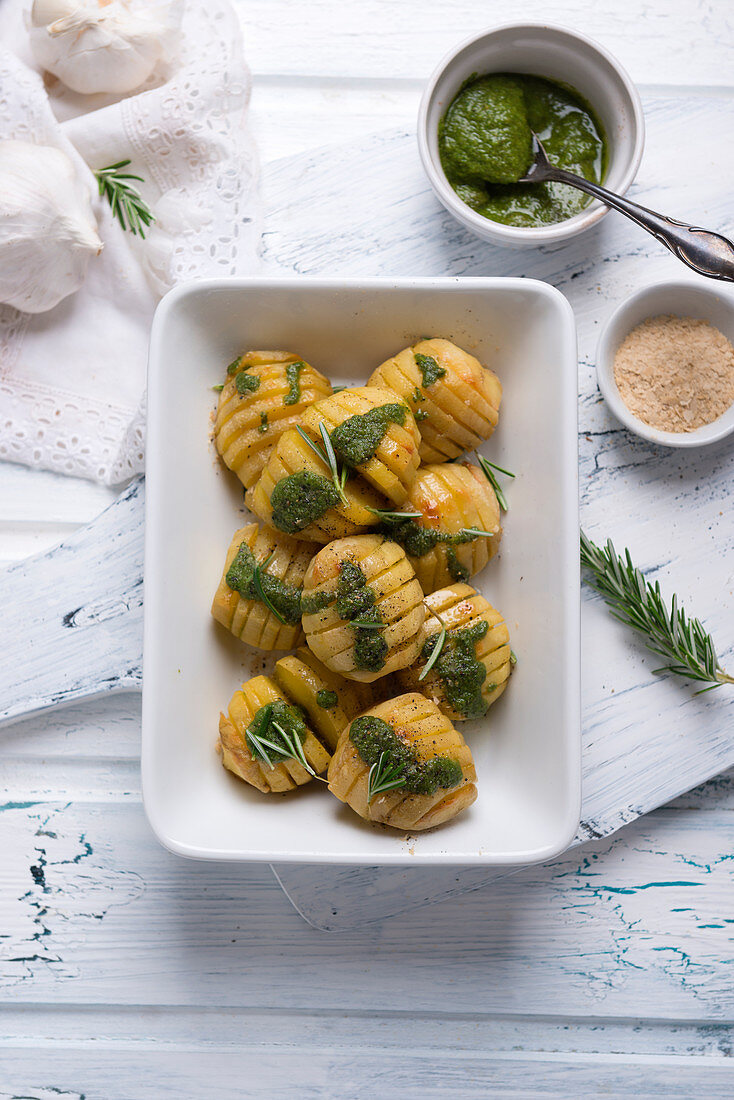 Hasselback potatoes with rosemary, green pesto and spiced yeast flakes