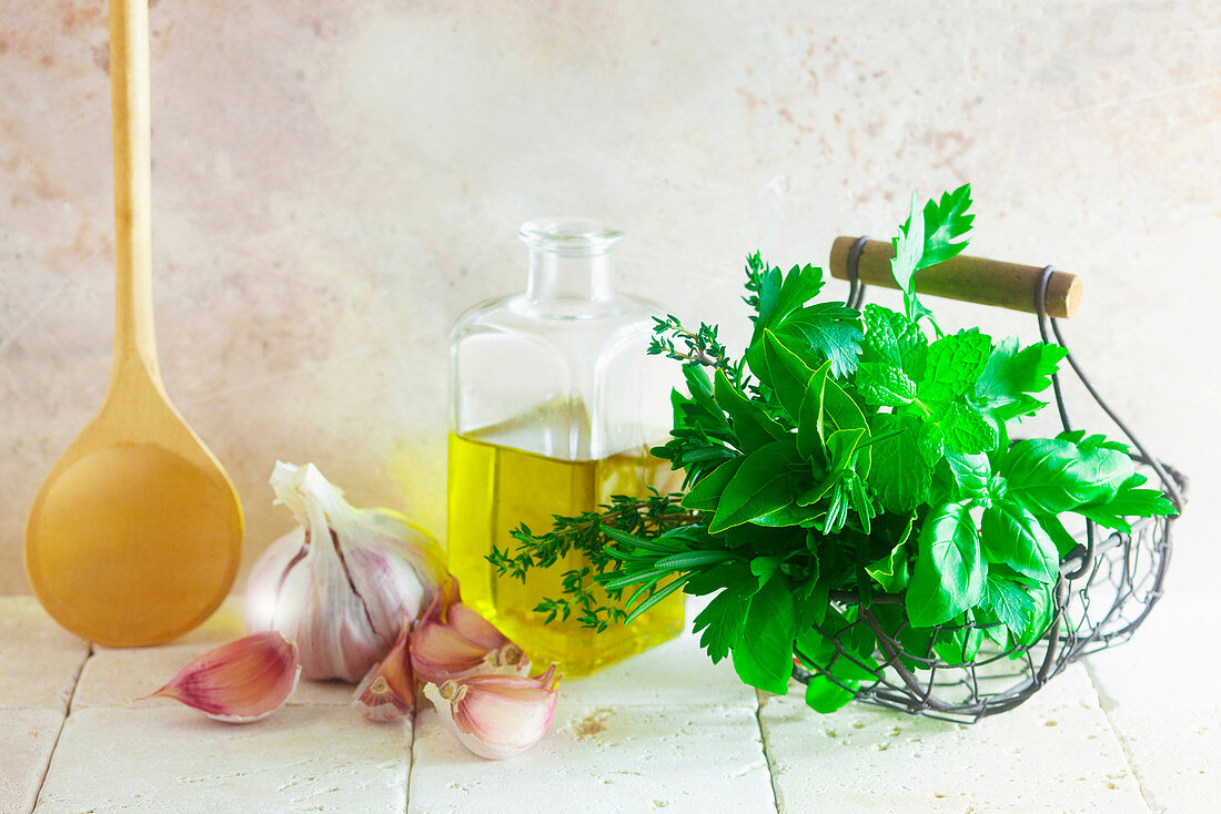 An arrangement of herbs, olive oil and garlic