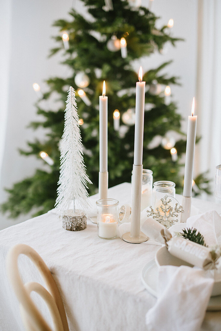 Candles on table set for Christmas in shades of cream