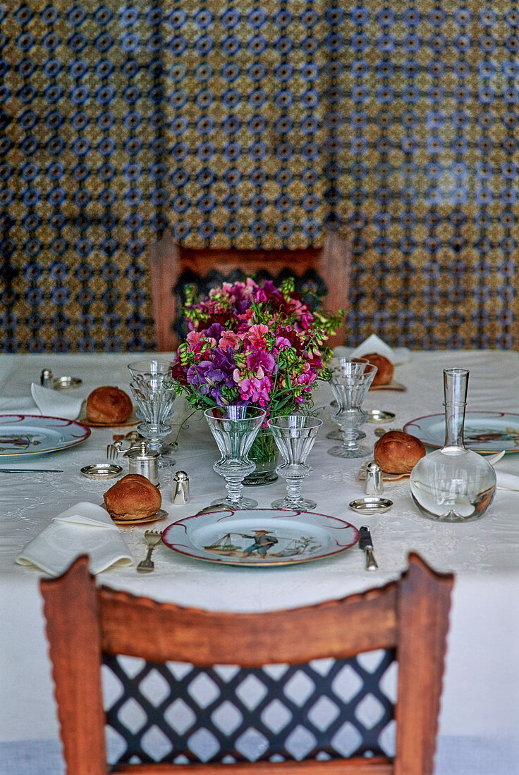 Gedeckter Tisch mit Weingläsern und Blumen