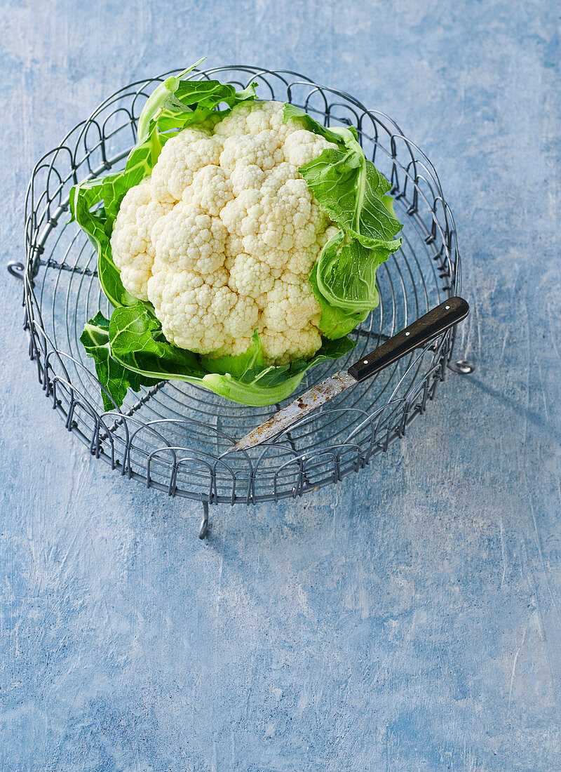 A cauliflower in a metal basket