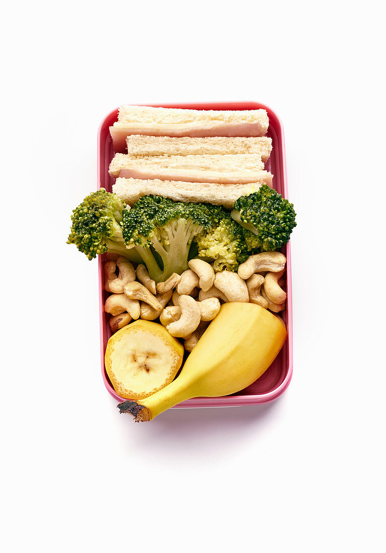 Lunchbox mit gesunder Mahlzeit aus Sandwich, Brokkoli, Cashewnüssen und Banane