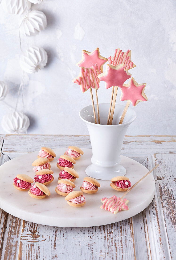 Süße Muschelkekse mit Cremefüllung und gebackene rosa Zauberstäbe