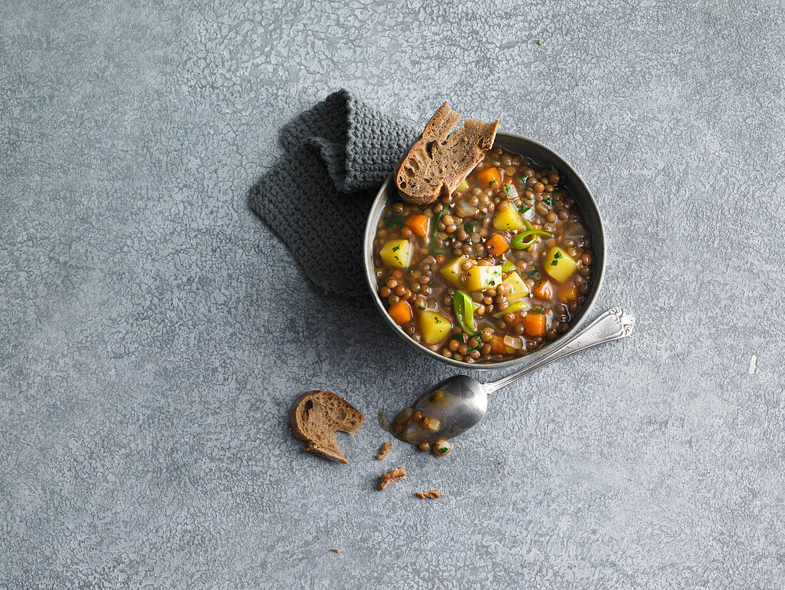 Lentil stew with potatoes and carrots served with bread