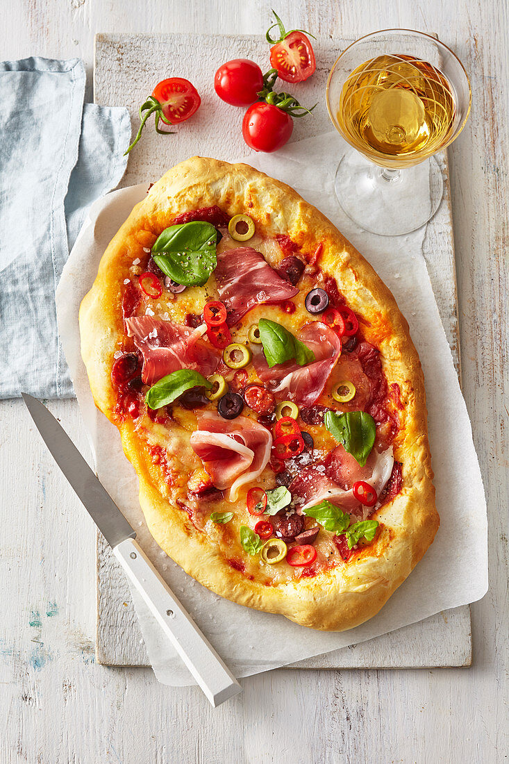 Italienische Pizza mit Parmaspeck und Oliven