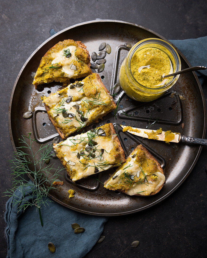 Überbackenes Brot mit Hokkaido-Aufstrich, veganem Käse, Kürbiskernen und Dill