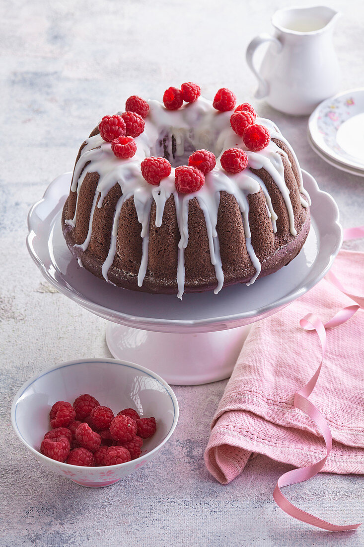 Chocolate wreath cake with icing and raspberries