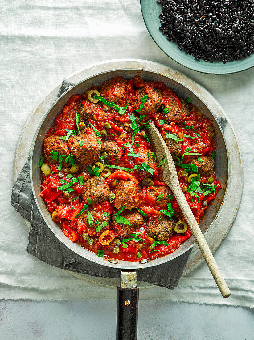Veggie meatballs with tomatoes, olives and caper sauce