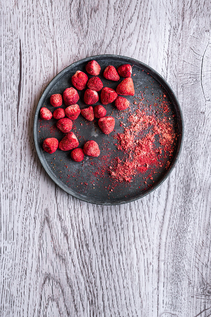Gefriergetrocknete Erdbeeren und Erdbeerpulver auf Teller