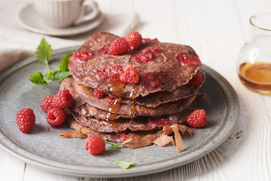 Cocoa pancakes with raspberries and maple syrup