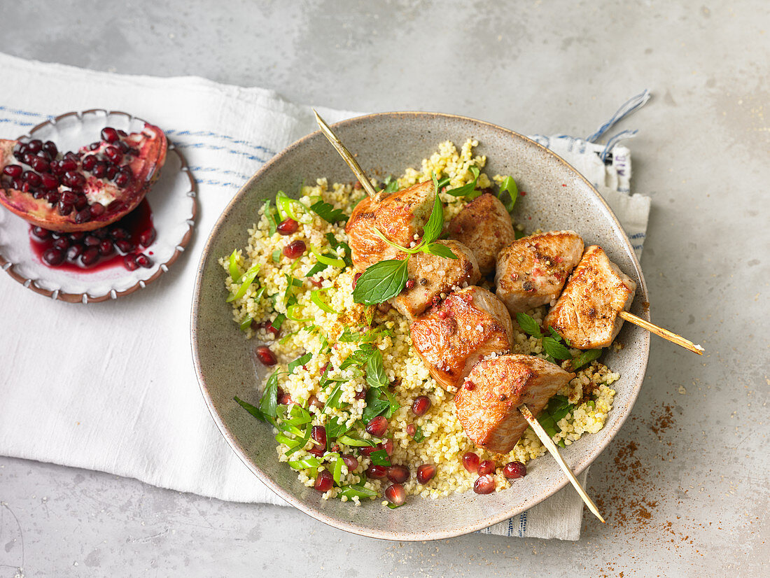 Oriental chicken kebab with couscous and pomegranate seeds