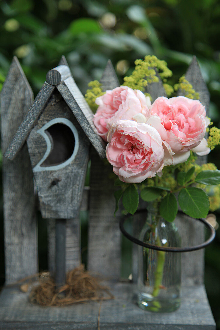 Rosenblüten in kleiner Glasflasche