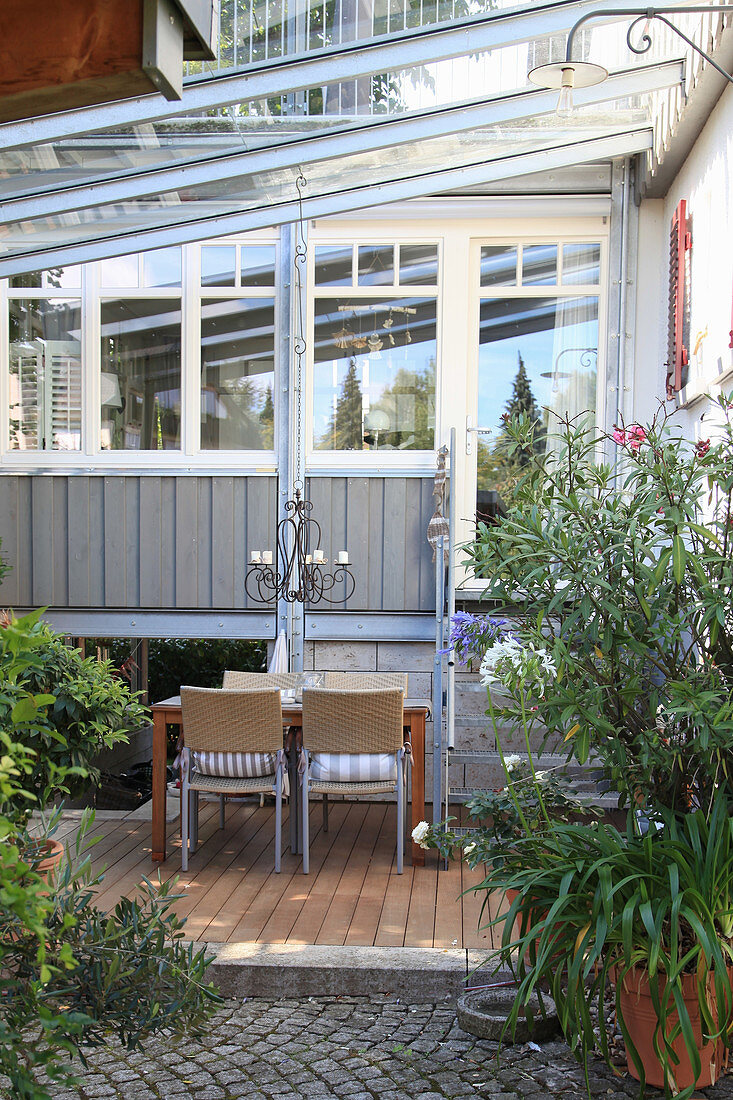 Sitzgruppe auf der Terrasse neben Treppe zum Wintergarten