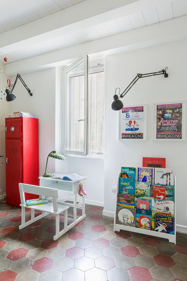 Wall-mounted lamps above school desk in child's bedroom with honeycomb floor tiles