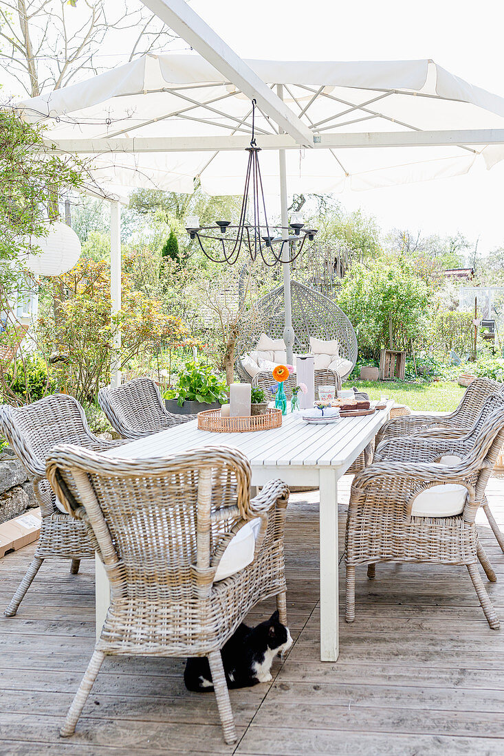 Wooden table and rattan armchairs on terrace