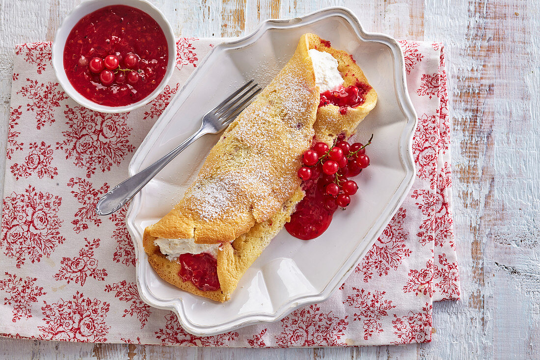 Fluffy pancakes with red berry sauce