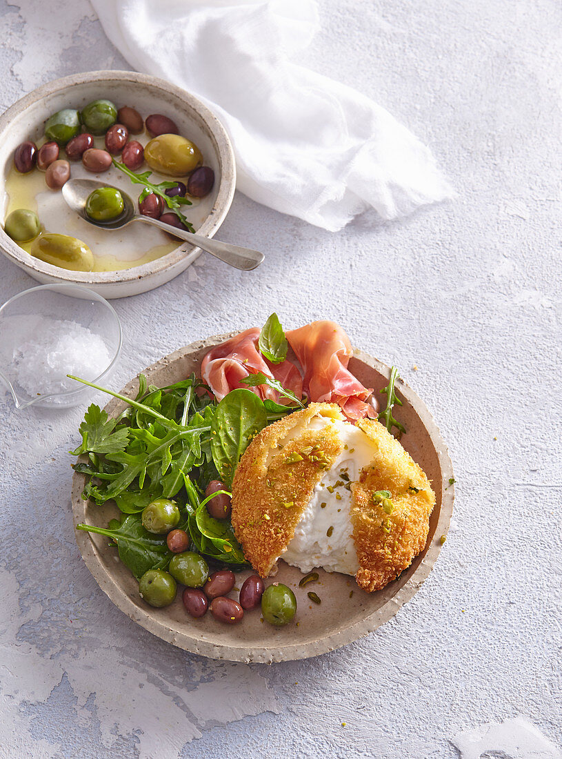 Fried mozzarella with prosciutto, olives and salad
