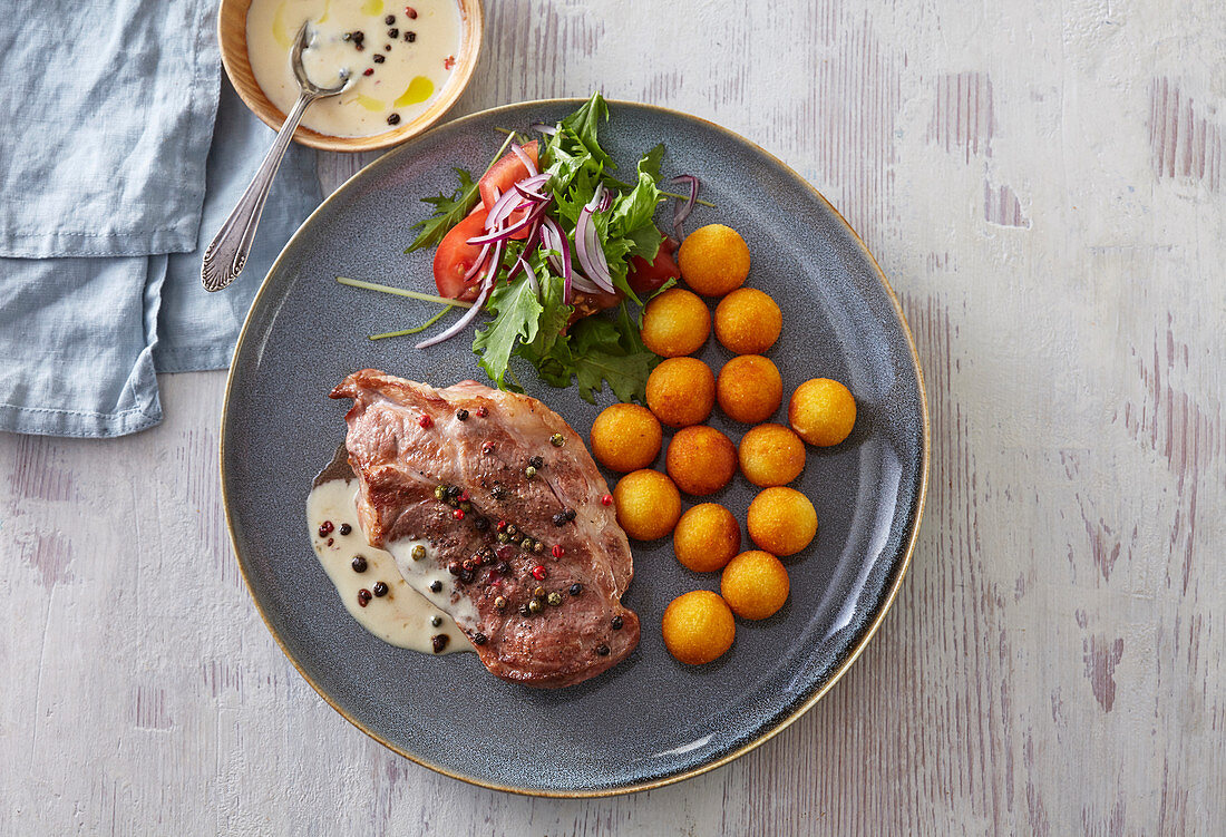 Schweinesteak mit Pfeffersauce und Krokettenbällchen