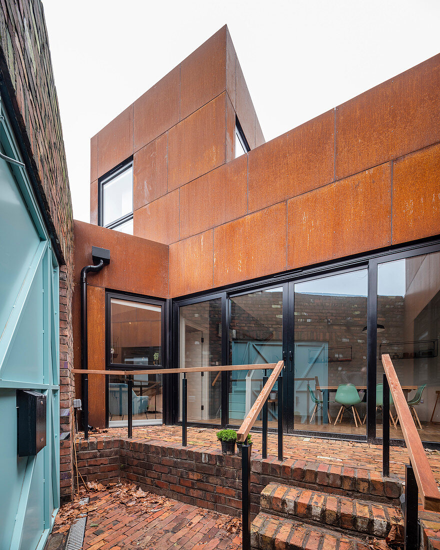 Modernes Architektenhaus mit rostiger Fassade und Glasfront