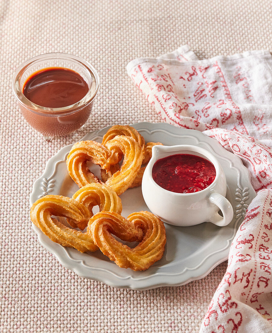 Heart-shaped churros with raspberry and chocolate sauce