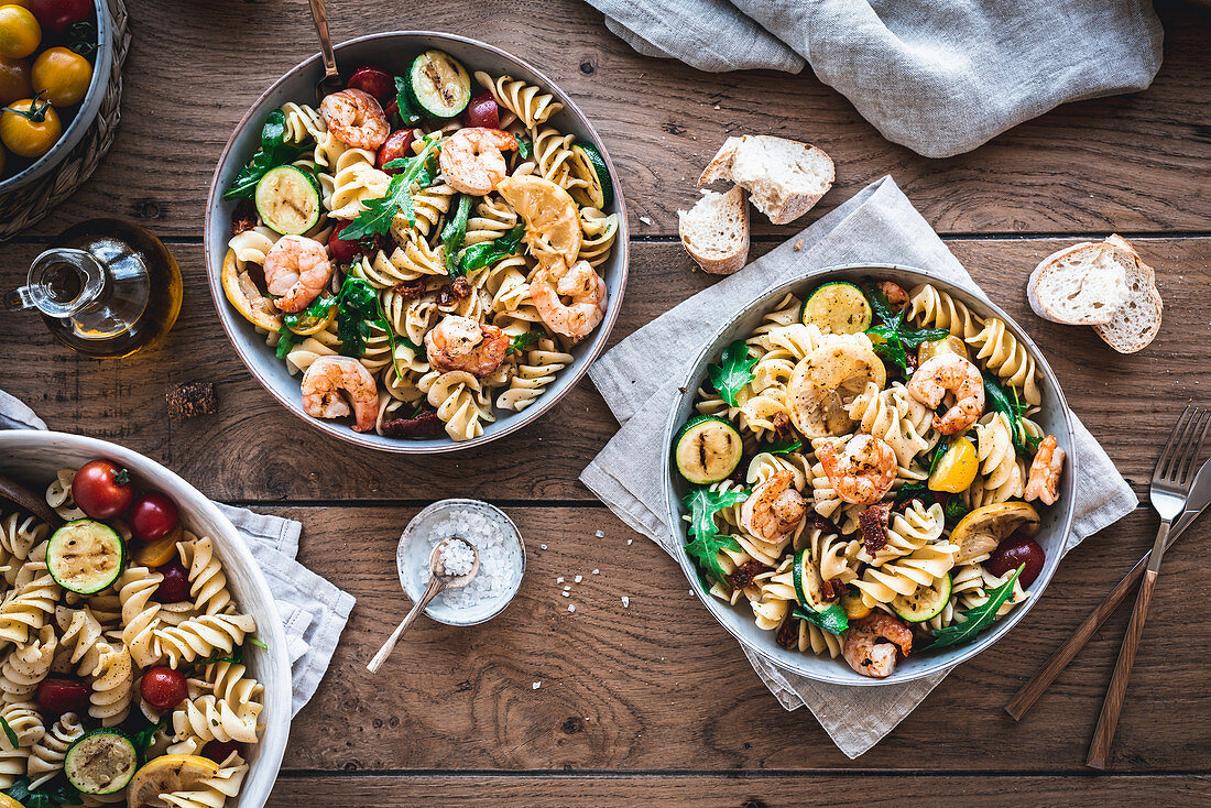 Mediterranean pasta salad with rocket, tomatoes and grilled prawns