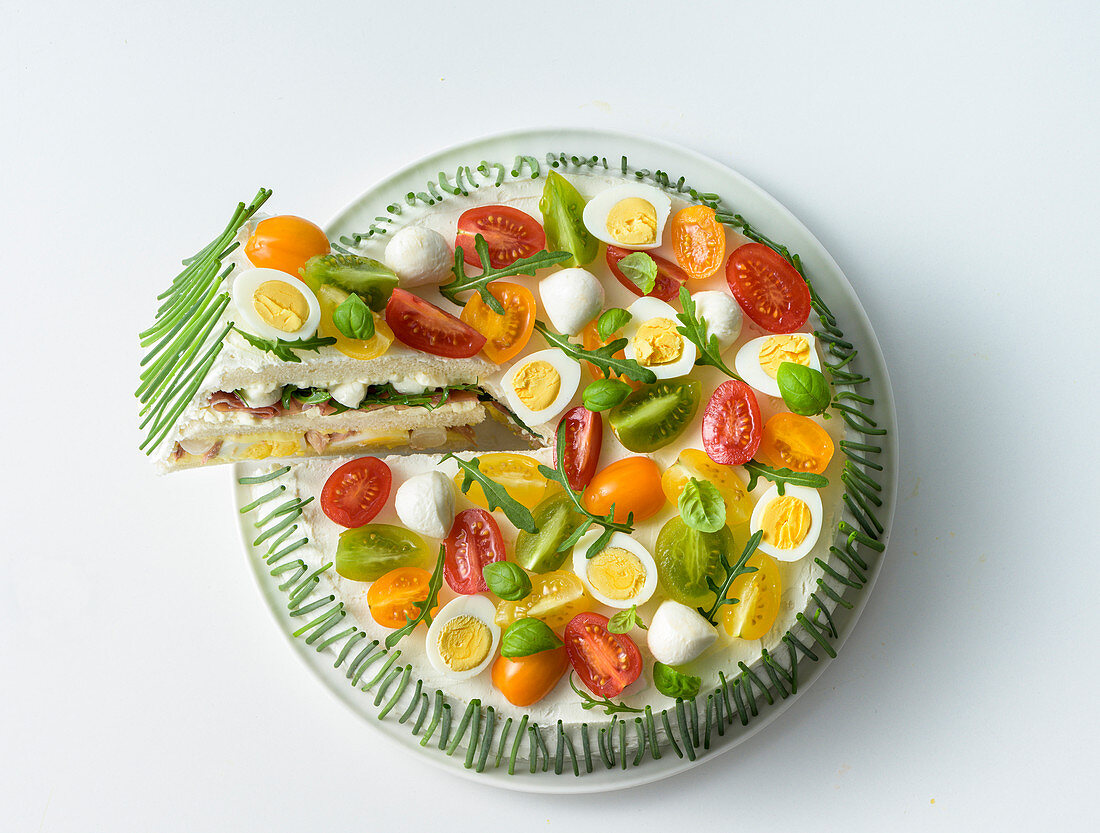 Sandwich cake with colourful cherry tomatoes and quail's eggs