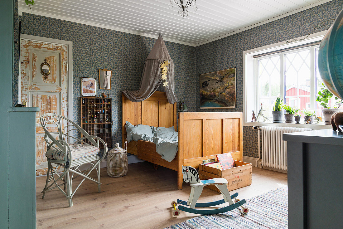 Antique wooden bed with crown, chair and rocking horse in child's bedroom