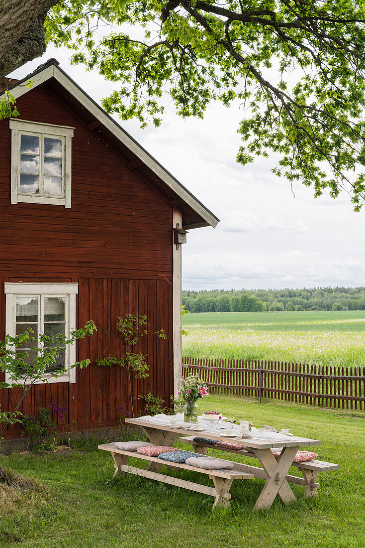 Tisch mit Bänken auf der Wiese im Garten