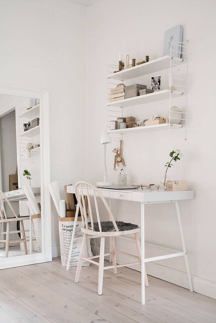 Dainty desk with chair and shelves in bright room