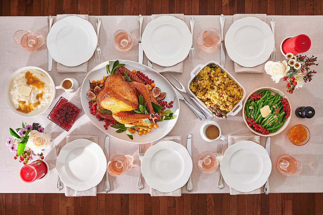 Set table with roast turkey and side dishes