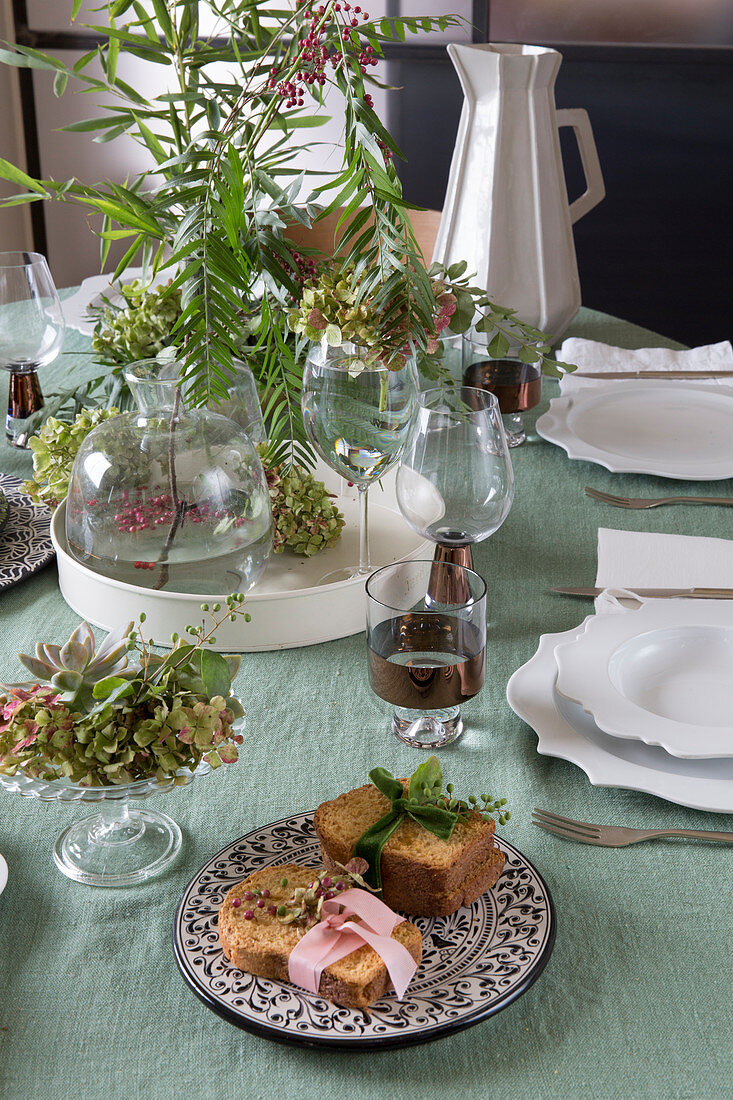 Bread with ribbons and flower arrangements on set table