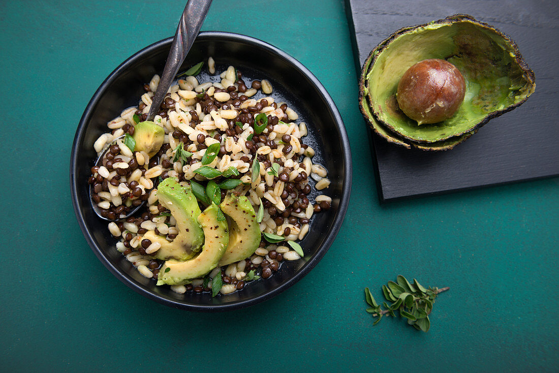 Vegan beluga lentil and wheat salad with avocado and spring onions
