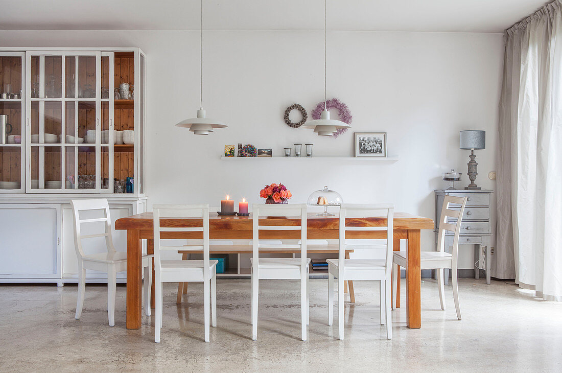 Esstisch aus Holz mit weißen Stühlen und Anrichte