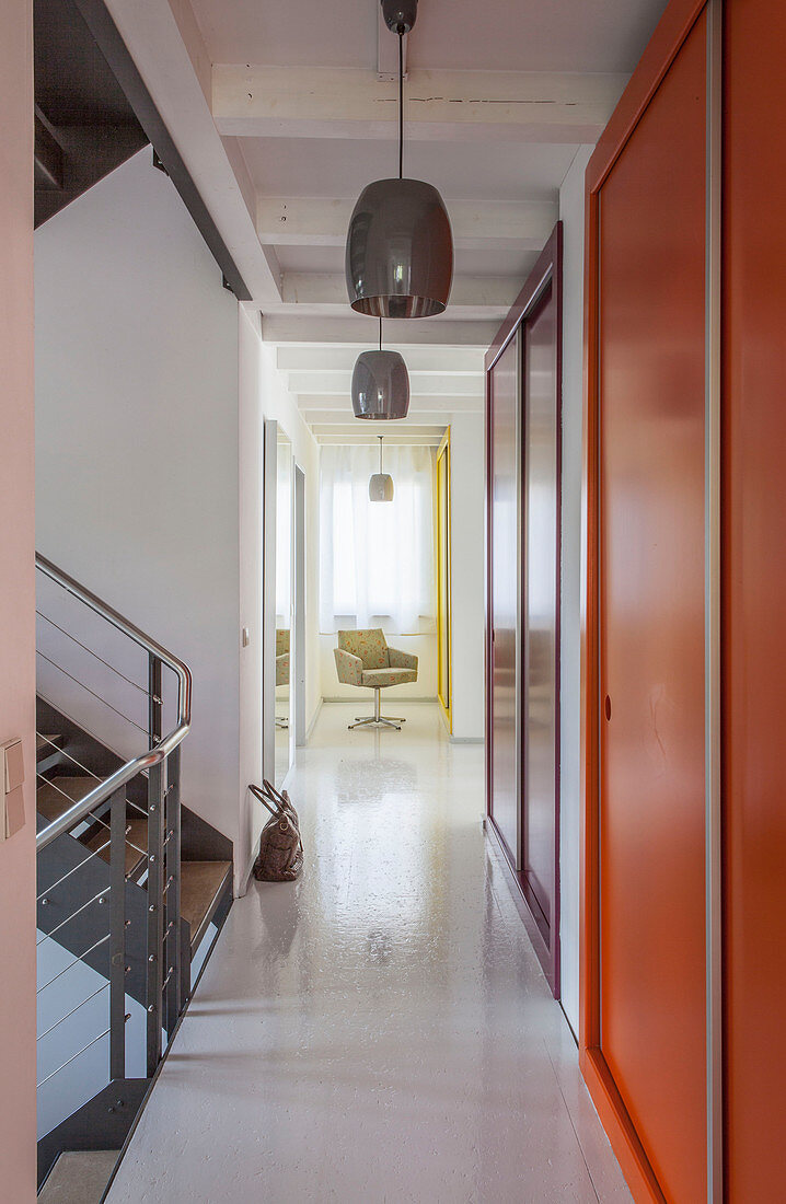 Long corridor with fitted cupboards and staircase