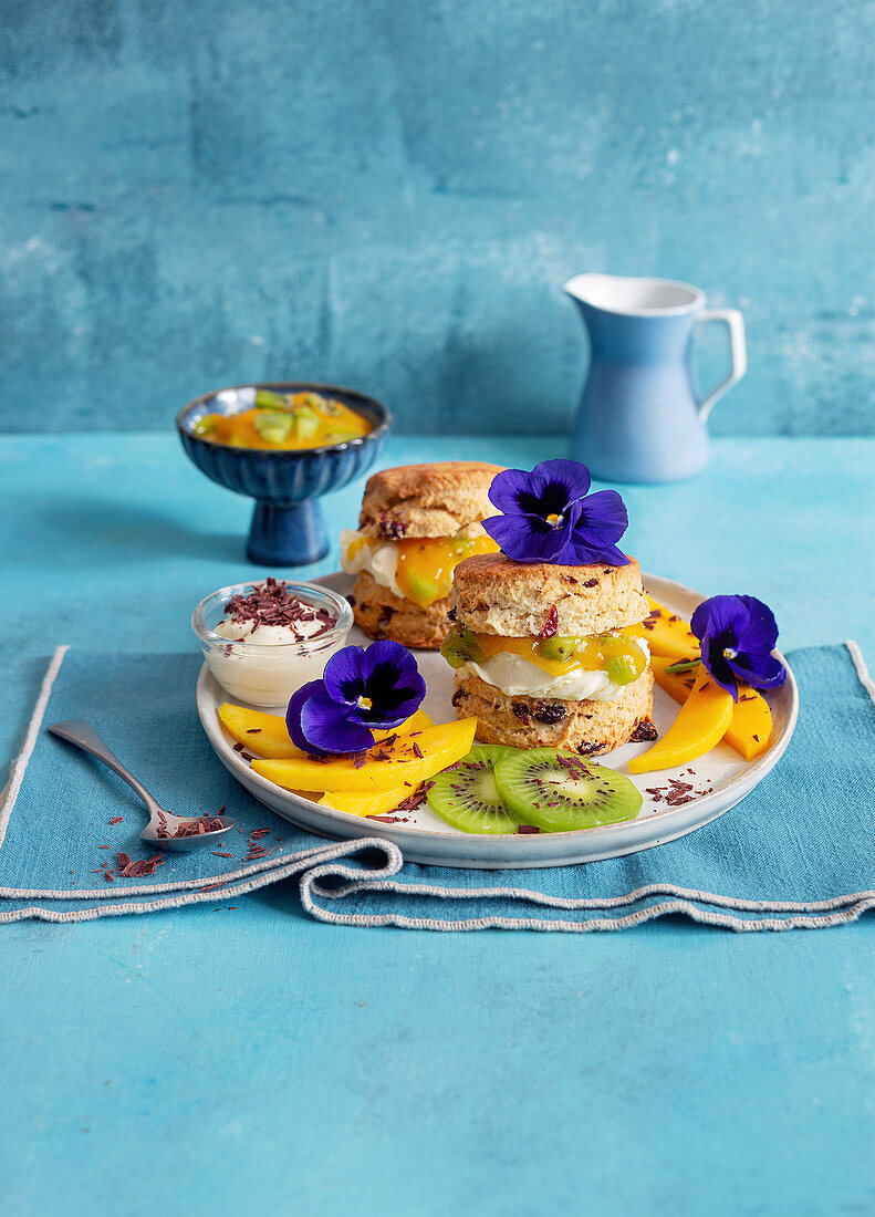 Cranberry scones with mango and kiwi cream and edible flowers