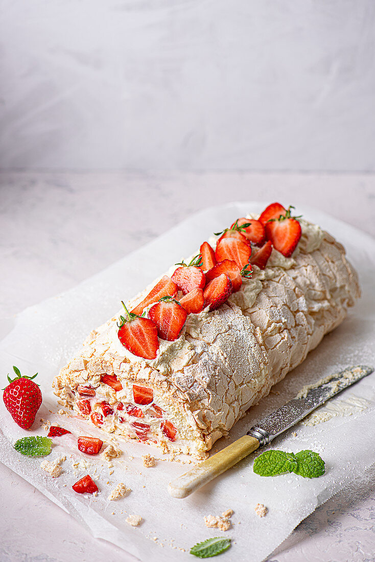 Meringue roulade with fresh whipped cream and strawberries