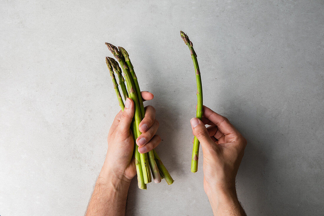 Cook holding bunch of fresh asparagus