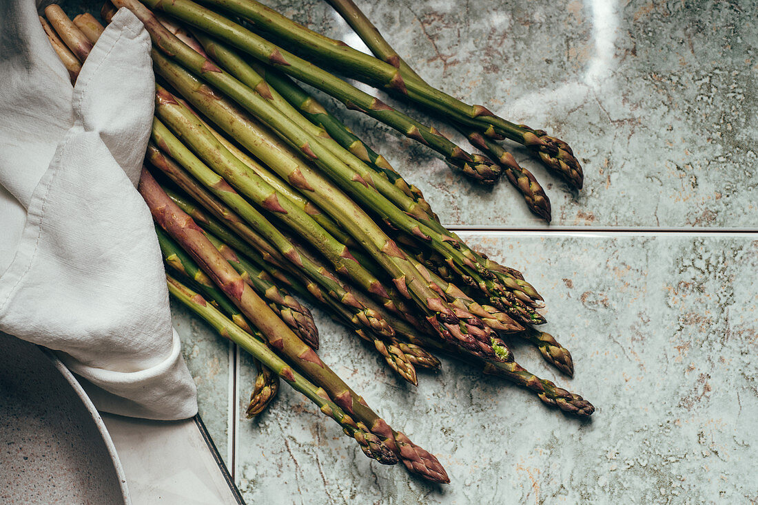 Raw organic asparagus spears, on rustic surface