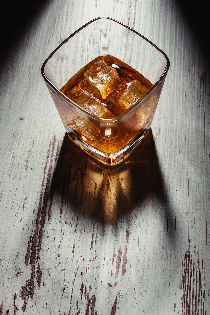 Glas Scotch mit Eiswürfeln auf rustikalem Holztisch