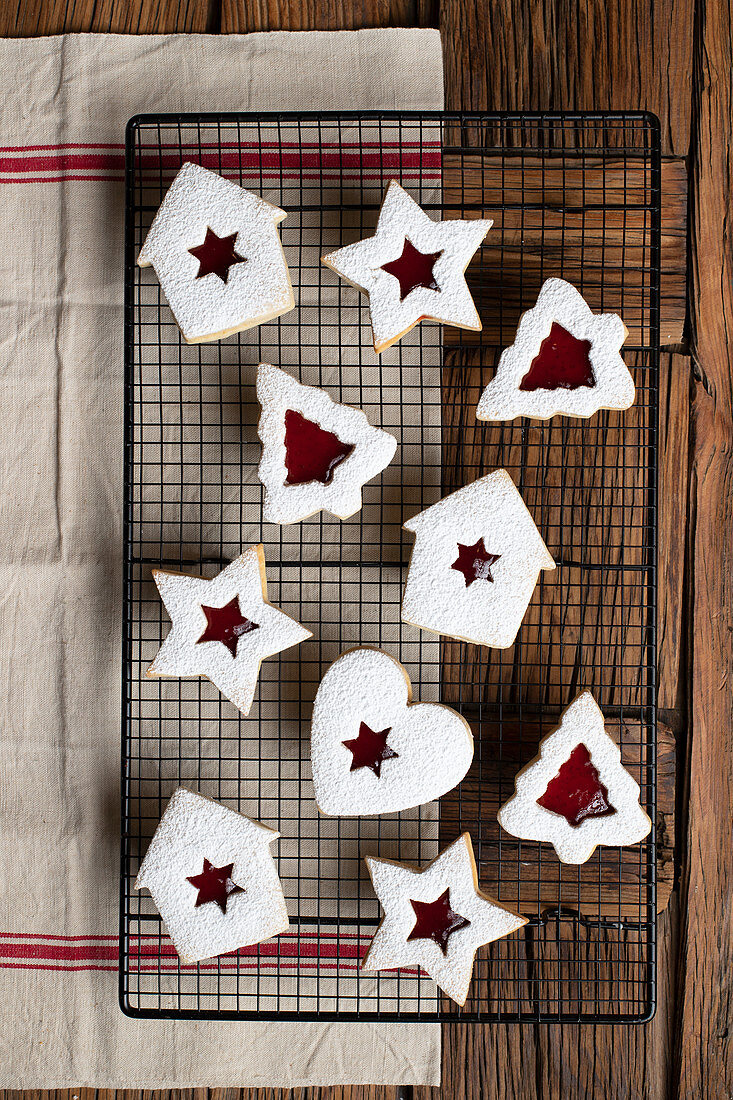 Homemade cookies of various shapes with red berry jam and white sugar powder for Christmas