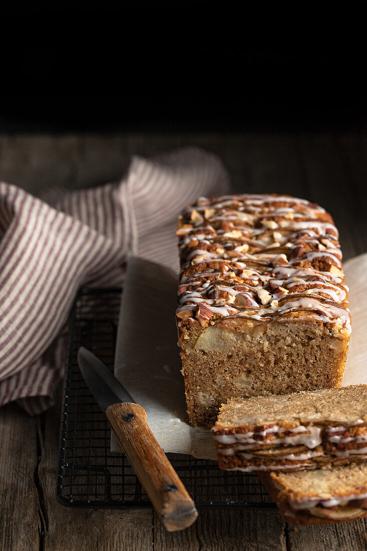 Hausgemachtes Bananenbrot mit Nüssen und Zuckerglasur auf Holztisch